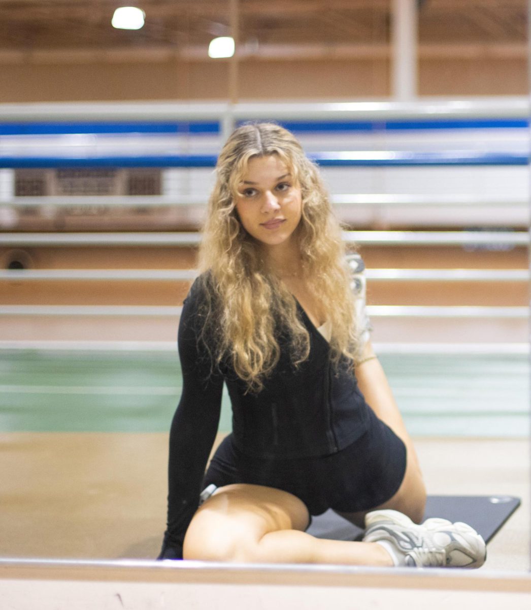 Monica Alifantis, a junior public relations major, stretches as she prepares for her workout in the Groniger Arena Sept 13.