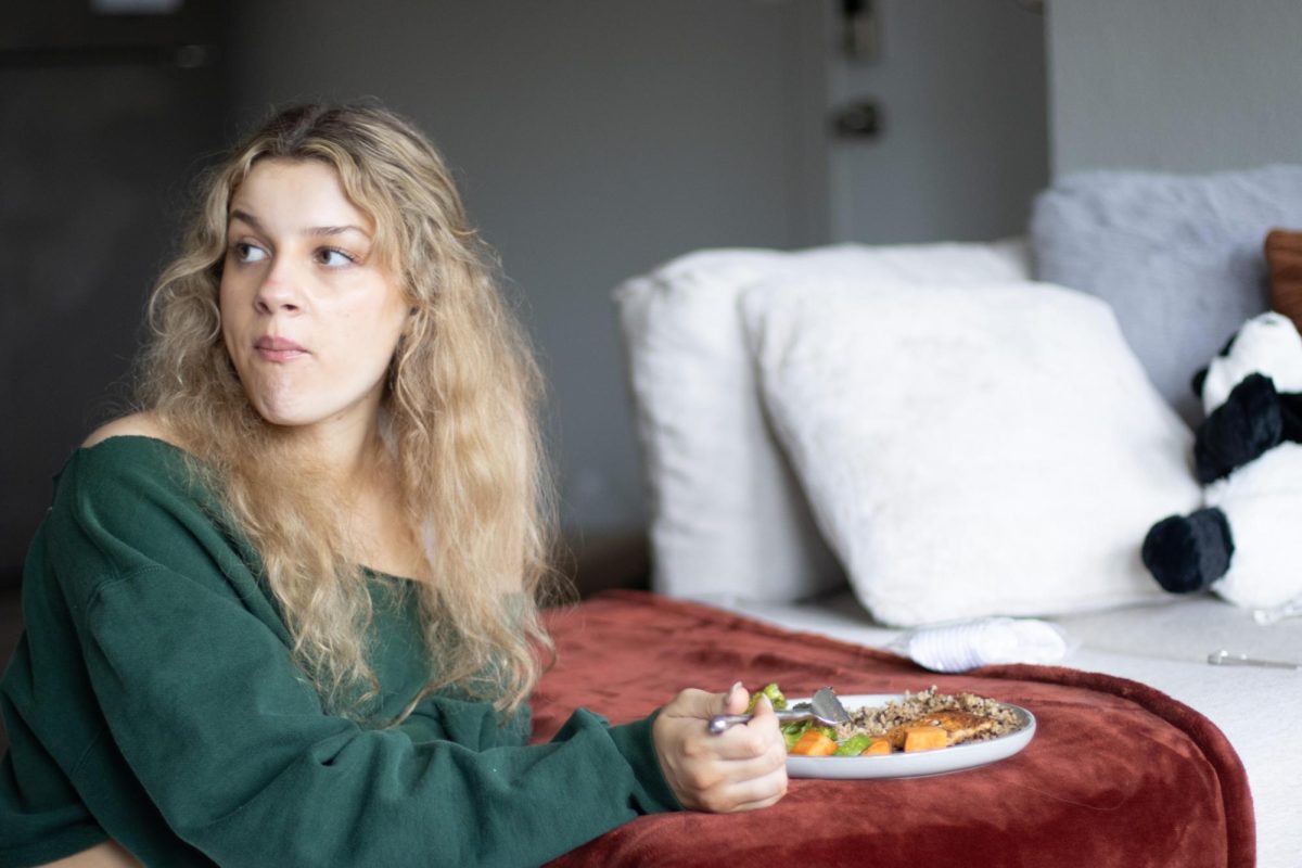 Monica Alifantis, a junior public relations major, watches Gilmore Girls while eating after her workout in her apartment.