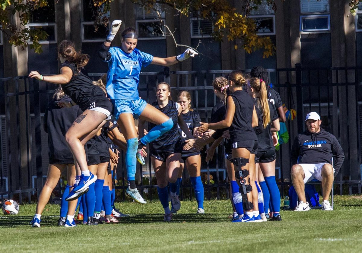 Goal Keeper Sophomore Ella Kratochvil of the women's soccer team, in the beginning of the game jumps up to bump team mate during the introduction of the game during the Eastern Illinois University Panther game vs Tennessee Teach Golden Eagles