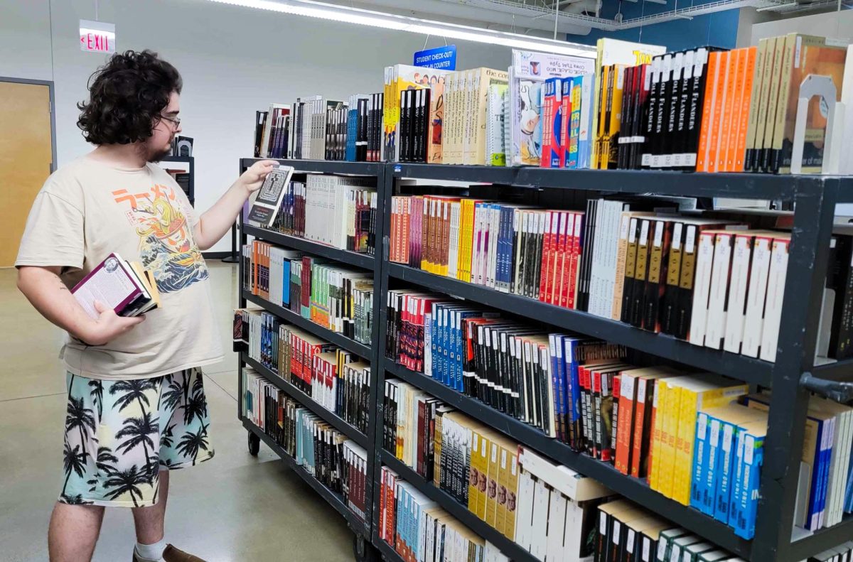 Junior English education major Calbe Willson looks at a novel at the discarded textbook sale at the Louis M. Grado Textbook Rental Center on Nov 6, 2024. On the Eastern Illinois University campus, Charleston Ill. 