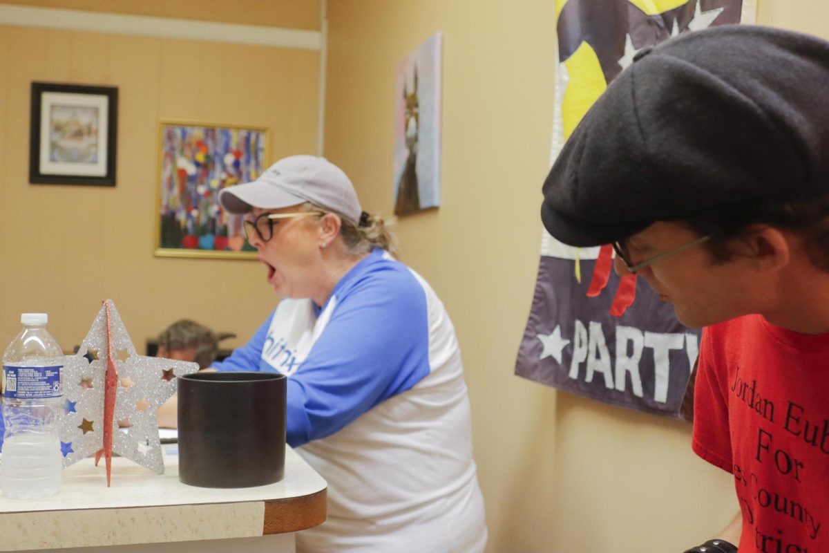 Jordan Eubanks looks over at Jenifer Whites phone to see what she’s reacting to while the County Board results come in at the Close county Democratic Party head quarters during its watch party of the 2024 election Tuesday, November 5, 2024. 