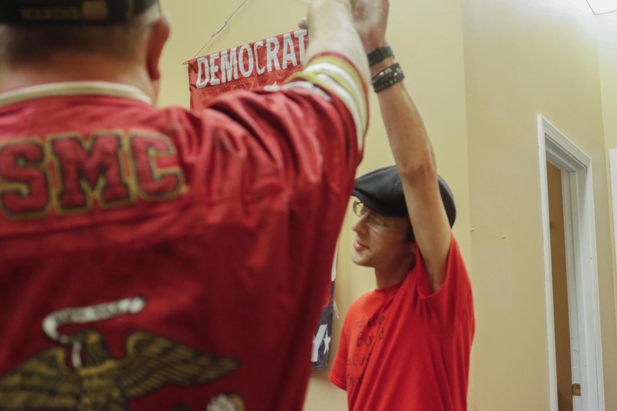 Doug Fagan and Jordan Eubank share a high five as they try to find solace awaiting the County Board election results at the Coles County Democratic Party headquarters Tuesday.