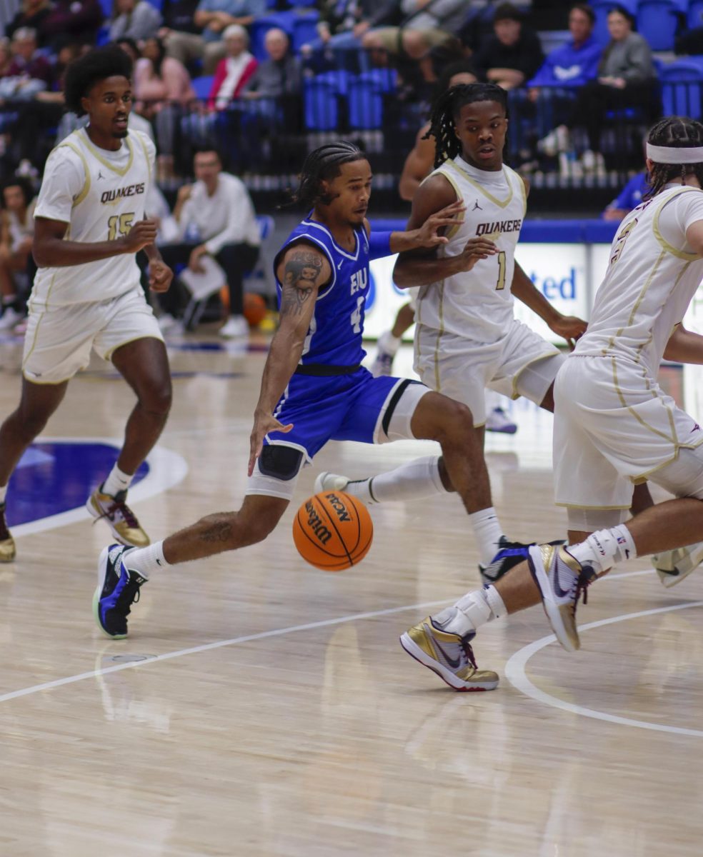 Sophomore Guard Isaiah Griffin takes the ball while surrounded by the Earlham Quakers , during The Eastern Illinois University against Earlham Quakers men basketball game at Groniger Arena,