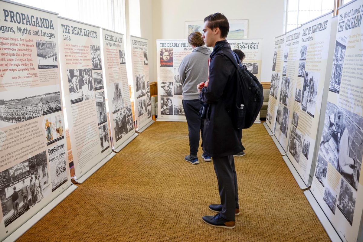 Junior history major Keegan Bottom observes at the “Courage to Remember Exhibit” in Booth Library on opening day on Jan. 27, 2025., which is Holocaust Remembrance Day and the day the Auschwitz concentration camp was liberated by the Red Army in 1945. 