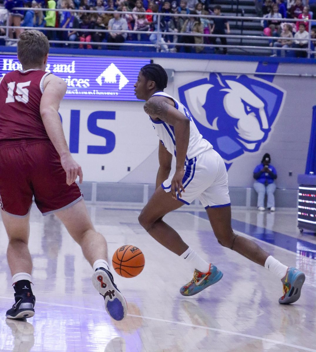 Freshman forward Terry McMorris dribbles the ball around the perimeter while being defended by sophomore forward Rasmus Westerlund during Eastern’s win against Calumet College of St. Joseph 87-57 at the Kid’s Day Game on Friday 