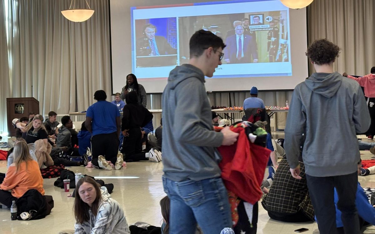 Students work on blankets as a community service opportunity while the presidential inauguration plays in the background Monday. The blankets will be donated to One Stop Christmas in the spirt of Martin Luther King Jr. 