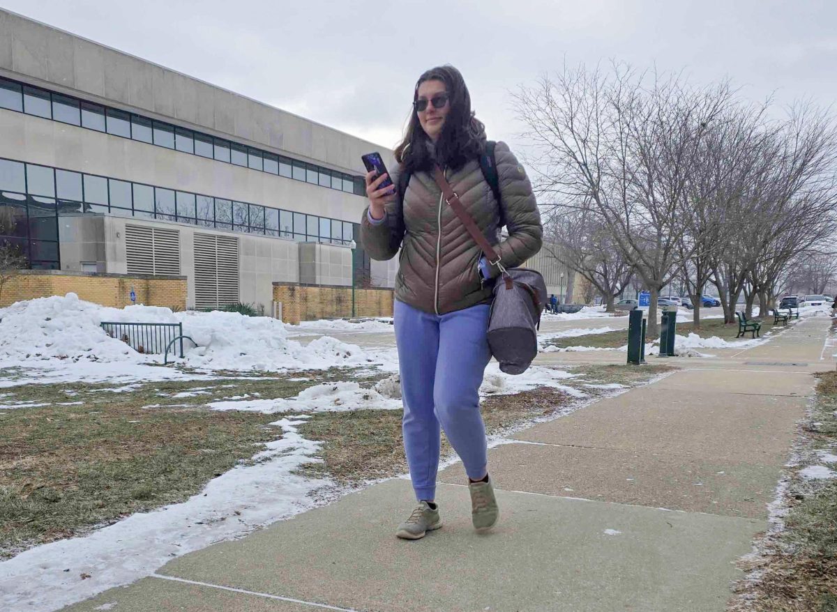 Senior early childhood education major Kyrah Estacio walks by the Life Sciences building after class while on her phone as she walks to her car.