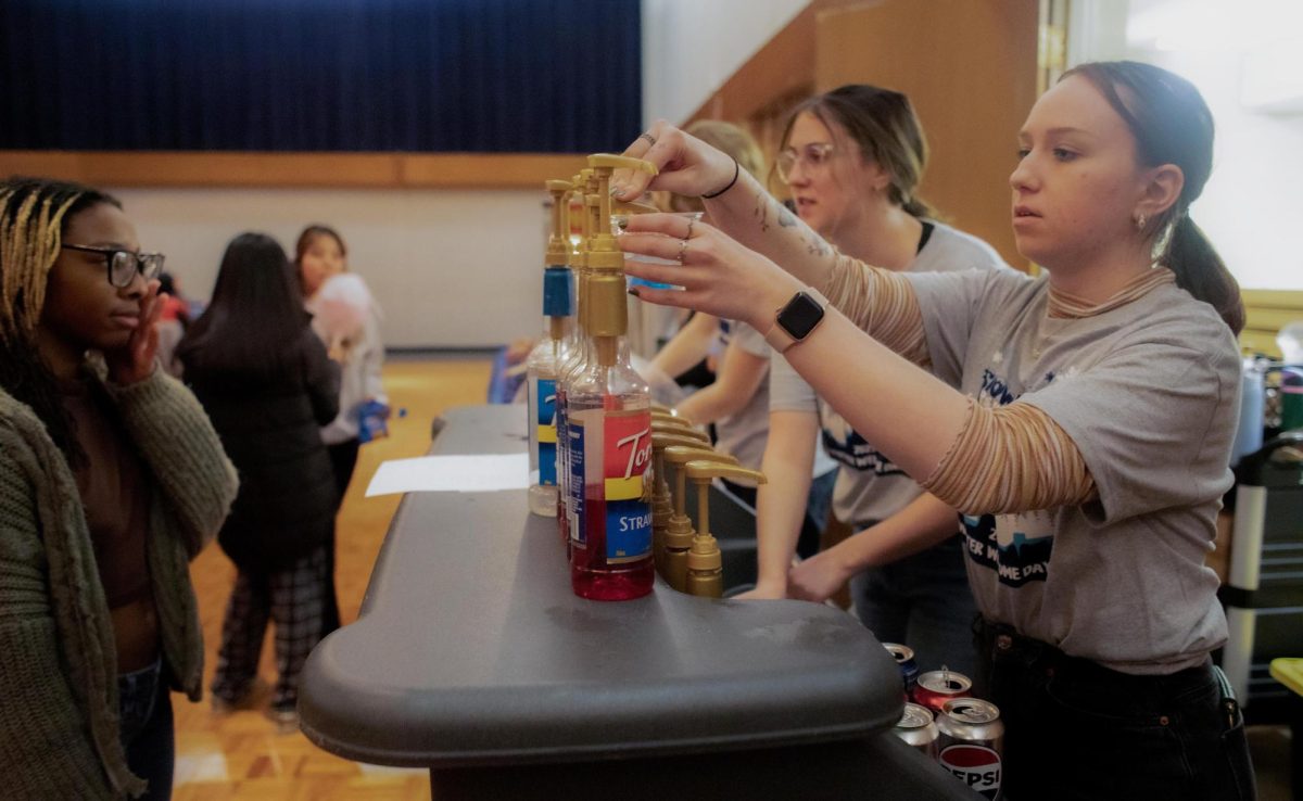 University Board member, junior Environmental Geography major Marissa Green, puts the flavored syrup into the mocktails and gives them out to students during the winter welcome dayz BINGO night, on Thursday evening.