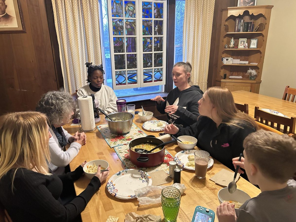 Members of the St. Hedwig Haus of Hospitality sit down to eat dinner on Jan. 24, 2025. The Hedwig Haus is a catholic worker house for women and children that serves as long-term housing. 