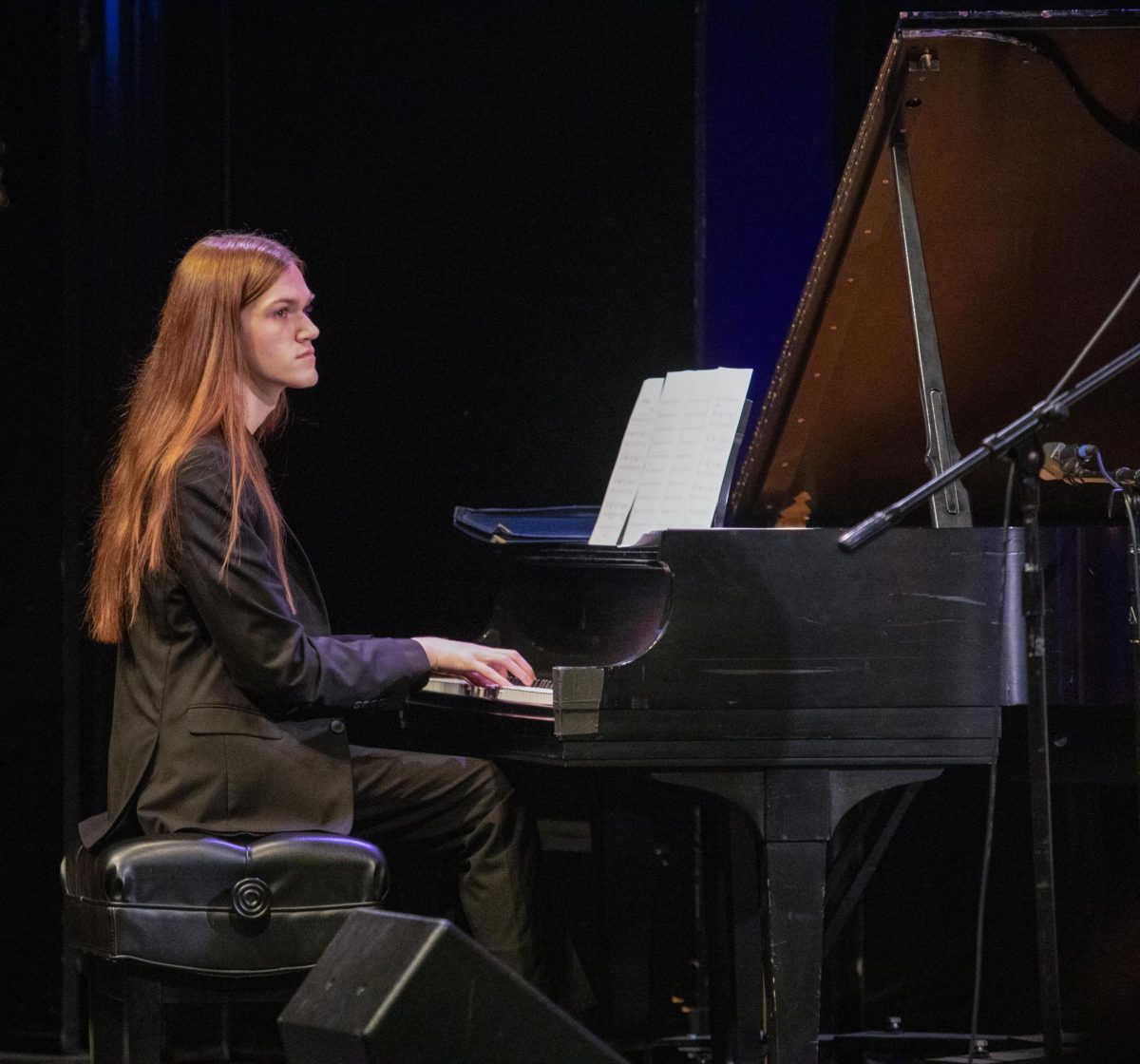 Pianist Jacob Reely looks up at the jazz director while playing a song during the first performance of the Eastern Jazz Festival.