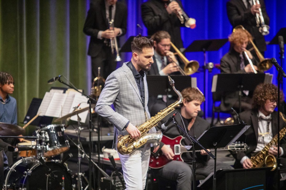 Saxophonist Chad LB taking a look at his music while resting during a jazz chart during the first performance of the Eastern Jazz Festival in the Theatre in the Doudna Fine Arts Center on Friday.