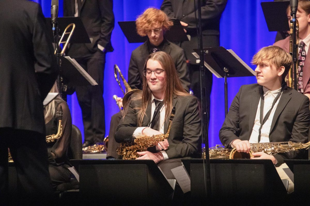 Saxophonists Kyle Rennier (Left) and Logan Webster (Right) smiling at saxophonist Chad LB soloing on a jazz chart during the first performance of the Eastern Jazz Festival in the Theatre in the Doudna Fine Arts Center on Friday.