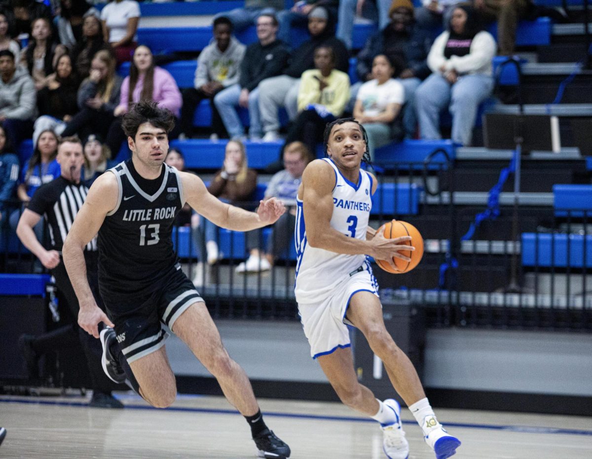 Eastern senior guard NaKyel Shelton prepares to go up for a layup while Little Rock sophomore guard Kristiyan Popov trails behind to stop him during the first half Eastern basketball’s win against Little Rock 71-60 at Groniger Arena on Thursday.