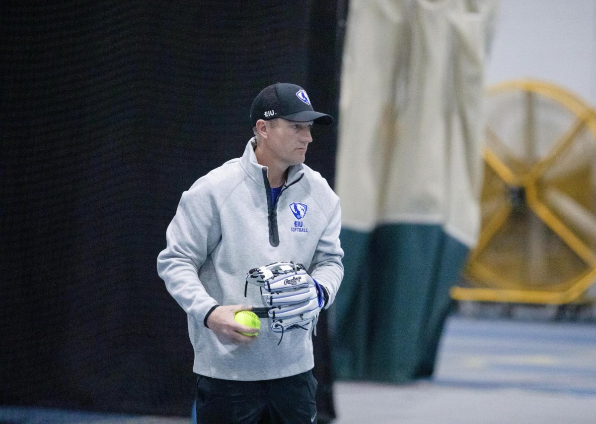 Softball Head Coach Dan Paulson gets ready to throw the ball at the infielders during one of the drills at practice on Tuesday.