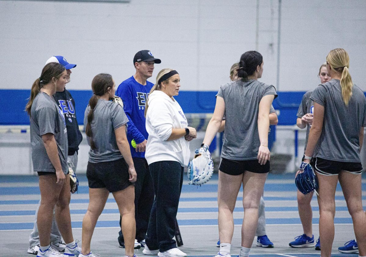 Softball co-head coaches Kristi and Dan Paulson talk with the infielders about how to improve after a fielding drill at practice on Tuesday.