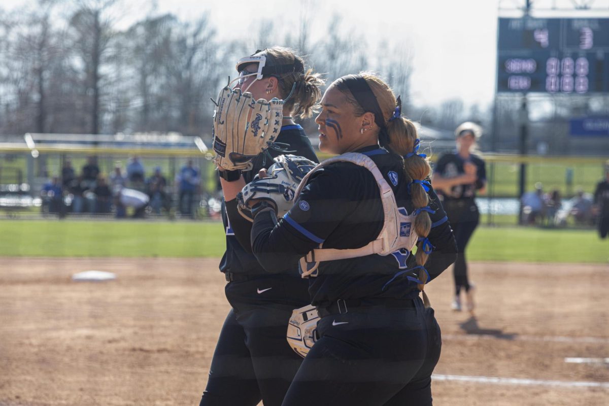 Eastern Illinois softball freshman catcher Kira Manganello and sophomore pitcher McKenzie Oslanzi tap gloves after the top of an inning at Williams Field during Eastern’s first game against Southeast Missouri State as Eastern split the games as Eastern lost the first game 3-0 and won the second 8-5 on Saturday.