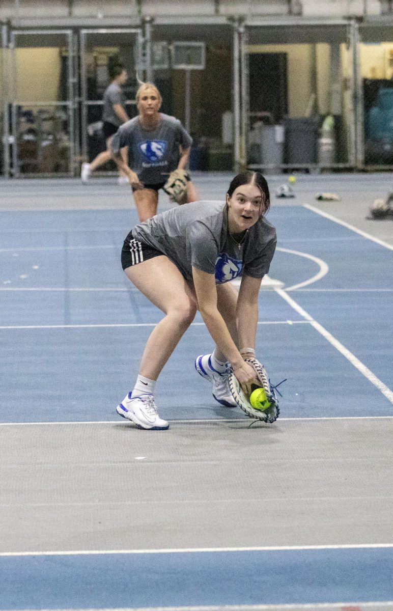 Eastern Illinois softball freshman utility player Abbi Hatton deciding on where to throw the ball after fielding a ground ball in a fielding drill during softball practice at the field house in Groniger arena on Tuesday Feb. 11.
