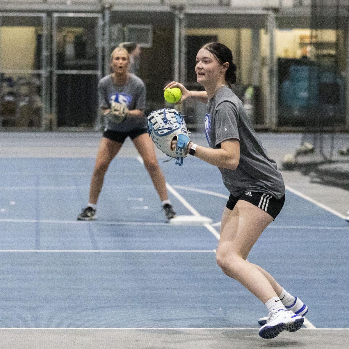 Eastern Illinois softball freshman utility player Abbi Hatton deciding to throw the softball to home plate in a fielding drill during softball practice at the field house in Groniger arena on Tuesday Feb. 11.