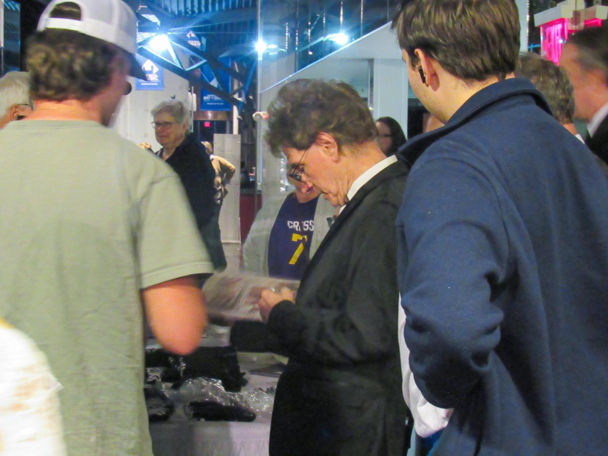 The Weeklings guitarist Bob Burger signs a vinyl record for a fan after The Weeklings Beatles Bash concert in the Dvorak Concert Hall in the Doudna Fine Arts Center on Saturday.