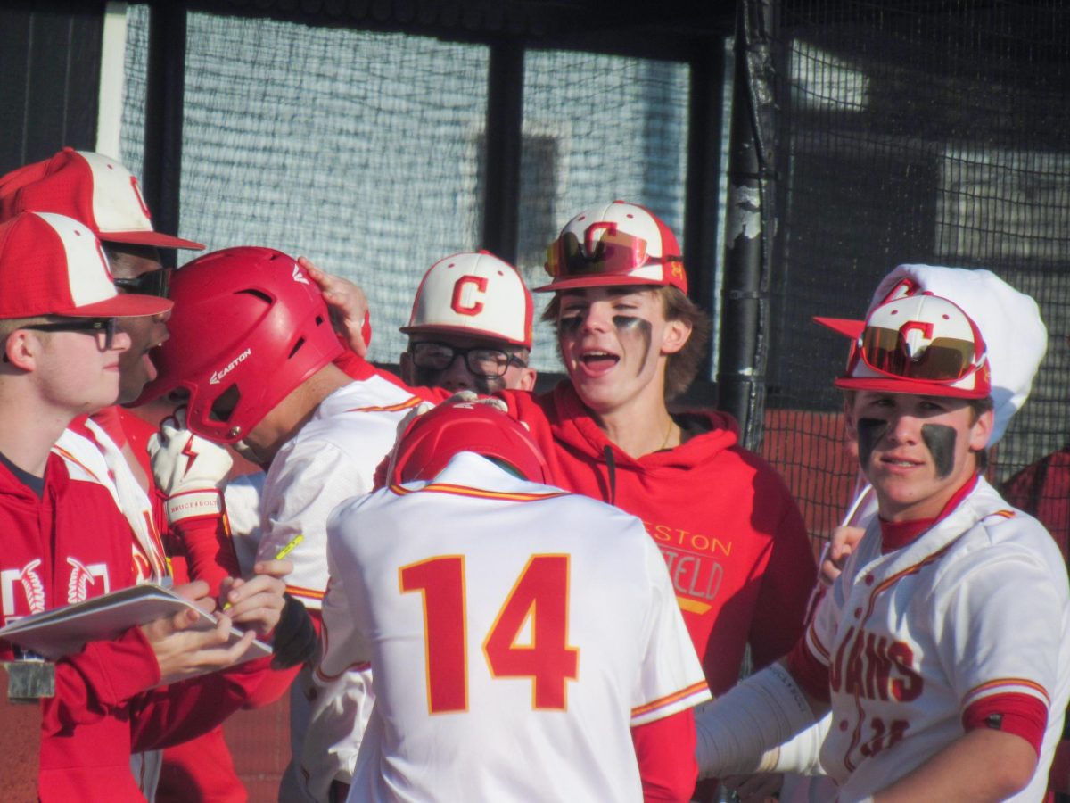 Charleston left fielder Rohen Walters being surrounded by his teammates after scoring a run from Russ Applegate's three RBI triple in the fourth inning of the Trojans 9-1 win over Shelbyville at Baker field on Friday April 11.