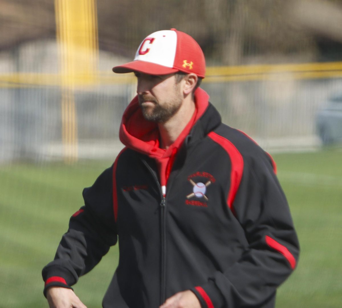 Charleston High School baseball head coach Daniel Bennett walking back to the dugout in between innings during game one of the Trojans' doubleheader against the Mattoon Greenwave as Charleston lost both games 12-8 and 5-4 on Monday April 7.