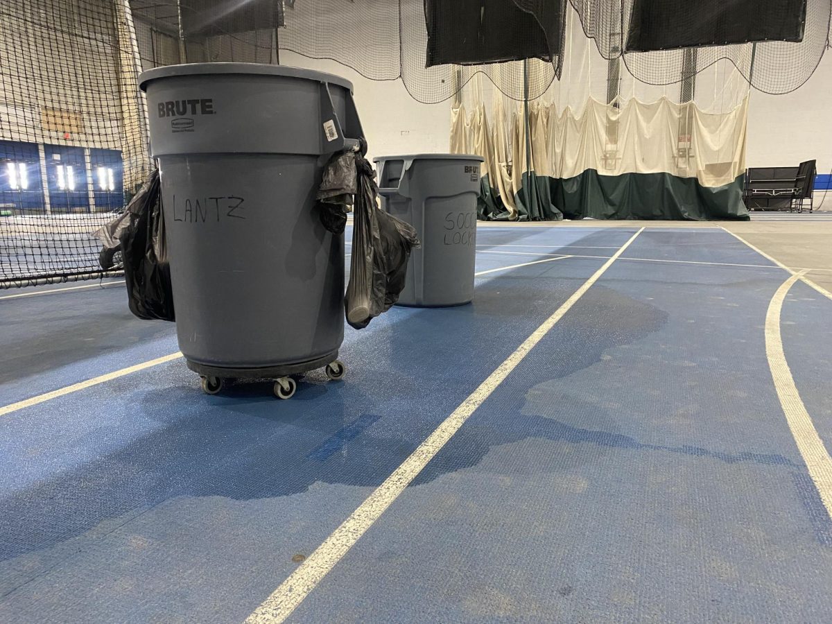 Garbage cans are placed on the main floor of the field house in Groniger Arena to catch the water that is still leaking from the roof on Monday.