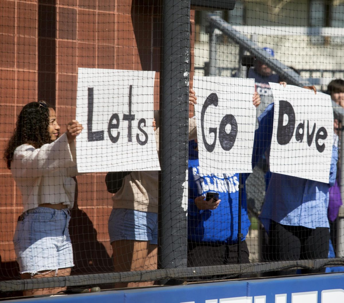 Members from the Fellowship of Christian Athletes holding up a we love Dave sign in support of senior infielder Briana Gonzalez’s dad as he is dealing with Sarcoma during Eastern’s win against Southern Indiana 5-2 at Williams field on Saturday April 12.
